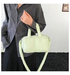 Close-up of mint green puffer tote bag with soft quilted texture and crossbody strap