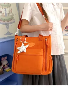 Trendy orange minimalist student messenger bag featuring a cute star charm detail