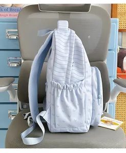 Side view of a light blue striped backpack with butterfly print on an office chair