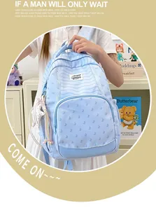 Detail view of a light blue striped student backpack with a cute star plush keychain accessory