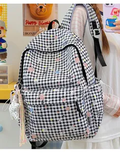 Japanischer süßer Rucksack mit Sternen und Karomuster, getragen von einem Modell im Detail