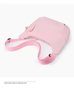 Close-up detail view of a stylish pink oxford crossbody bag with woven adjustable strap.