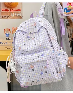 Lifestyle-Ansicht eines lila karierten Rucksacks mit bunten Sternen und Anhängern.