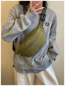 Casual olive green crossbody chest bag shown on a model wearing a grey sweatshirt