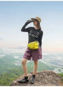 Outdoor-Lifestyle-Foto einer gelben Lauftasche mit Flaschenhalter am Wanderer