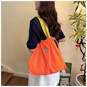 Back view of model wearing a large capacity vibrant orange waterproof drawstring shopping bag