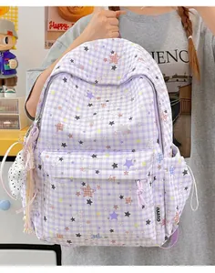 Detail eines lila karierten Rucksacks mit bunten Sternmustern und süßem Anhänger