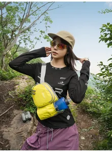 Gelbe Sport-Brusttasche mit Wasserflasche an einer Wanderin im Freien gezeigt