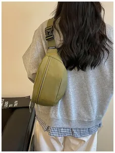 Detail back view of a model wearing a stylish olive green American high street chest bag