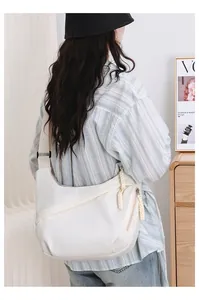Back view of a woman wearing a white casual Oxford crossbody chest bag indoors