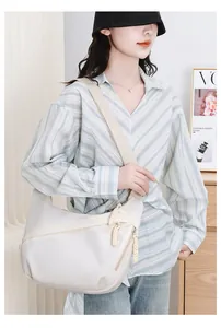 Detailed view of fashionable white oxford crossbody chest bag worn by an Asian model