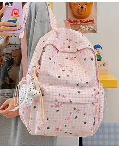 Detailansicht eines rosa karierten Rucksacks mit Sternen und einem Plüschanhänger.