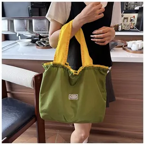 Detail view of a green eco-friendly foldable drawstring shopping bag with yellow handles