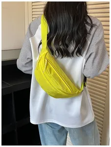 Detailed view of neon yellow crossbody waist bag worn on a casual street style outfit