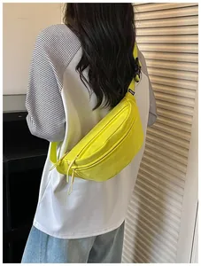 Close-up of vibrant yellow nylon crossbody bag worn by a model in casual outfit