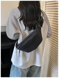 Back view of a minimalist black nylon chest bag with adjustable strap and zippers