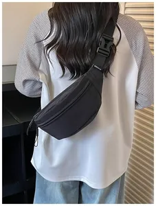 Black high-street style crossbody fanny pack worn over a raglan sleeve t-shirt