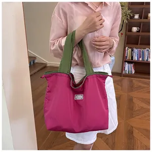 Detailed lifestyle view of a large fuchsia drawstring shopping bag with olive green handles