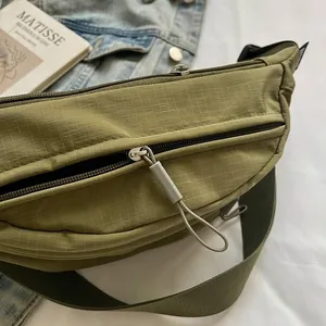 Green grid textured casual crossbody bag with zipper detail and adjustable nylon strap