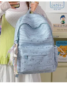 Detail of light blue tie-dye backpack with hanging star pendant and embossed hearts