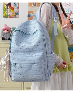 Detail of light blue tie-dye backpack with embossed bow and heart patterns for girls