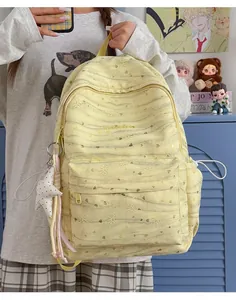 Close-up detail of yellow tie-dye student backpack with heart patterns and star charm