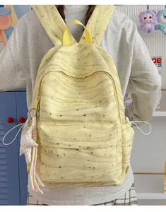 Rear view of a yellow tie-dye backpack with star charm and cutout floral patterns.