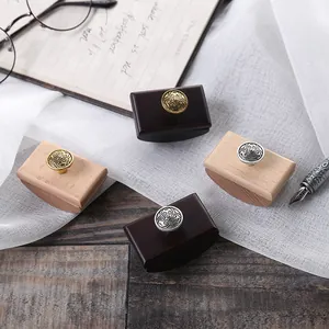Close-up of wooden rocker ink blotters with ornate gold and silver metal knobs