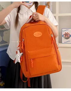 Detailed view of vibrant orange water-resistant student backpack with a large capacity design