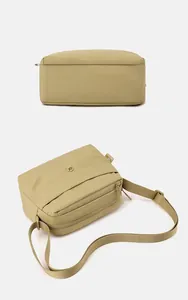 Vista dettagliata della borsa a tracolla leggera in nylon kaki con scomparti con cerniera.
