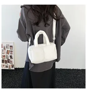 Stylish white padded down cotton tote bag shown as a crossbody bag in a street style view