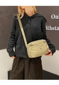 Modella che indossa una borsa a tracolla in nylon kaki leggero con cinturino