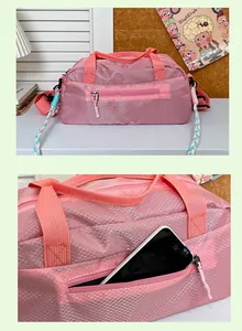 Detailed view of pink quilted sports bag with a side zipper pocket for smartphone storage