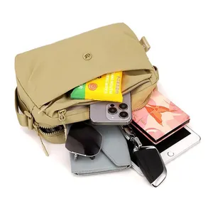 Grande borsa a tracolla in nylon kaki che mostra la capacità con oggetti comuni