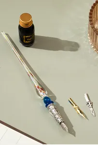 Detalle del set de pluma de inmersión de cristal con botella de tinta y plumillas