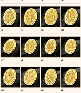 Vintage gold metal wax seal stamps featuring a collection of decorative script letters