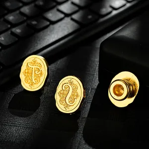 Vintage oval gold metal wax seal stamp heads with elegant alphabet letter engravings.
