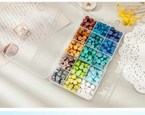Close-up of colorful octagonal sealing wax beads organized in a 15-grid transparent box