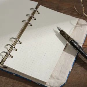 Retro cloth-covered ring binder notebook with dot grid paper and vintage pen