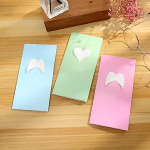 Set of creative hollow greeting cards with heart and wing designs on a wooden surface