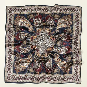 Vue détaillée d'un foulard carré en satin bleu marine avec motifs paisley et fleurs élégants