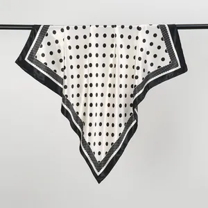 Detail of a large 90cm square silk scarf featuring a classic black polka dot pattern