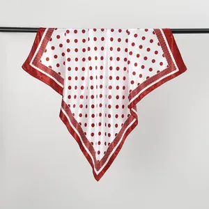 Close-up detail of a fashion red and white polka dot satin silk scarf elegantly draped for display