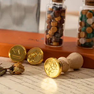 Retro-Siegellack-Set mit Messingköpfen, Holzgriff und Wachsperlen auf Vintage-Papier