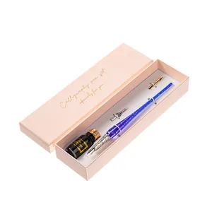 Elegante set de caligrafía con pluma de vidrio y tinta en una caja de regalo rosa fina.