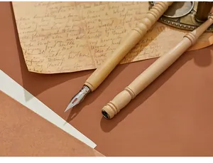 Κοντινό πλάνο vintage ξύλινης πένας με μεταλλική μύτη σε παλαιωμένο φόντο χαρτιού