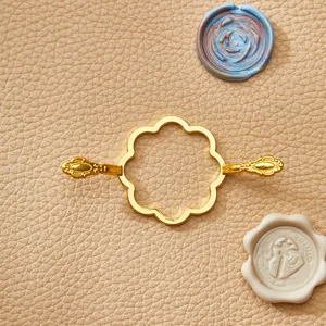 Molde elegante de metal dorado con forma de flor para posicionar sellos de lacre decorativos