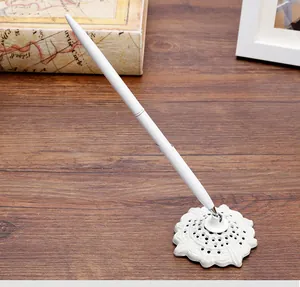 Elegante bolígrafo de metal blanco con un soporte de base floral decorativo ornamentado