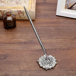 Elegante bolígrafo de escritorio de metal plateado con base de filigrana en madera