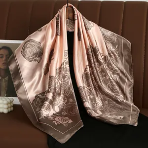 Detail view of pink and brown rose floral satin square scarf with elegant silky texture.
